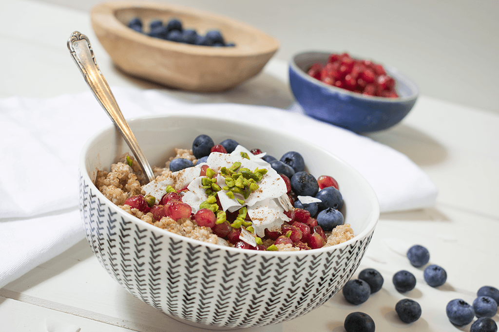 Quinoa-Porridge mit Blaubeeren, Granatapfel, Kokosflocken und Pistazien